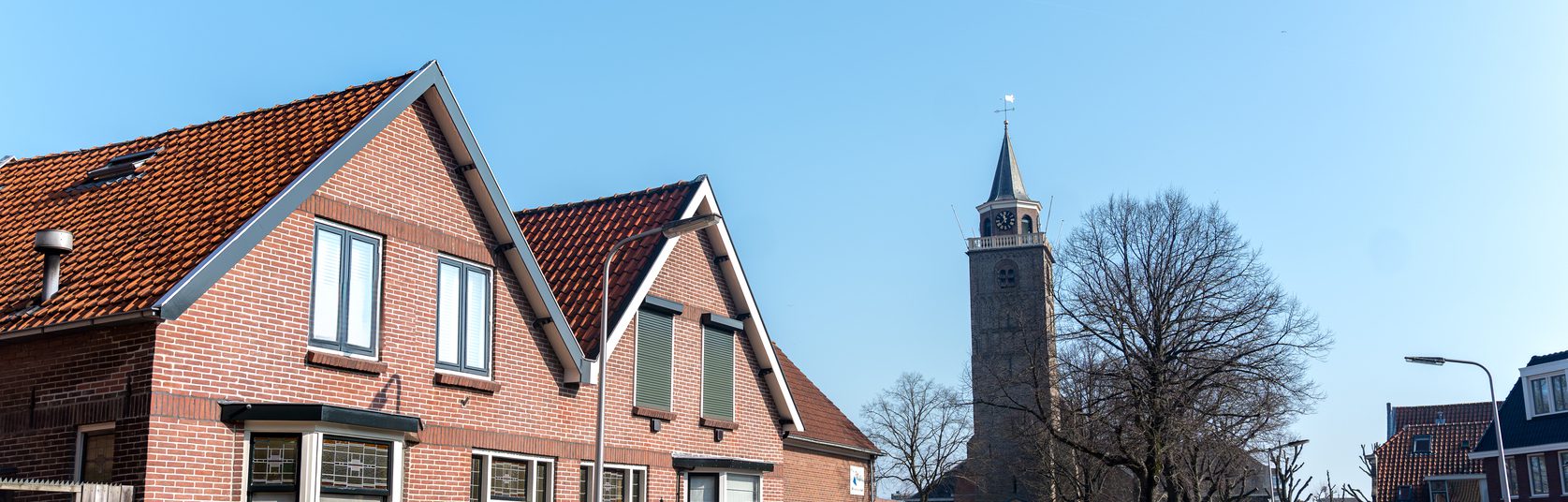 Straatbeeld van woningen in Rijnsburg met de kerk op de achtergrond